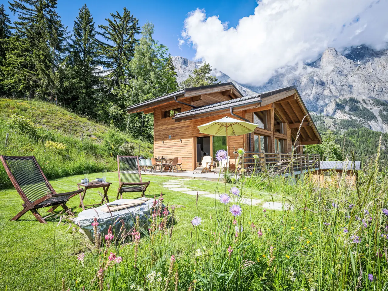 Chalet La Luna in de zomer, met bloemenweide en de bergen van Wallis op de achtergrond